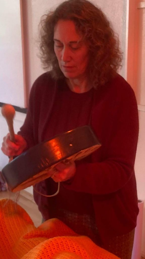 Reiki Master Christine Ashton holding a drum